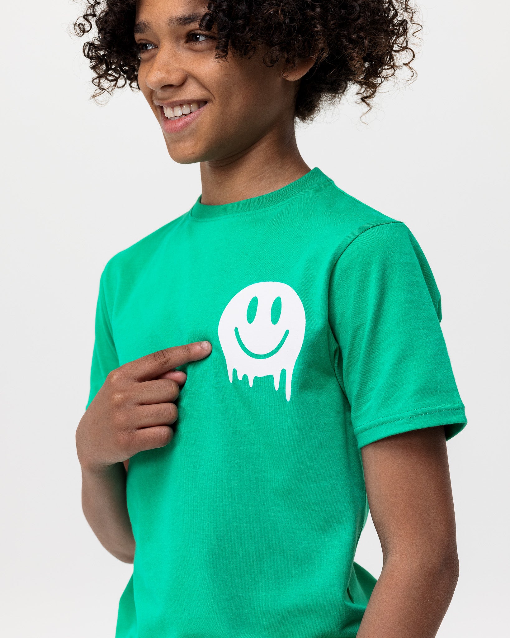 boy wearing Rascal green smiley face tshirt smiling and pointing at white smiley face graphic