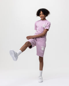 boy model wearing Rascal pink jogger smiley face shorts and pink smiley tee