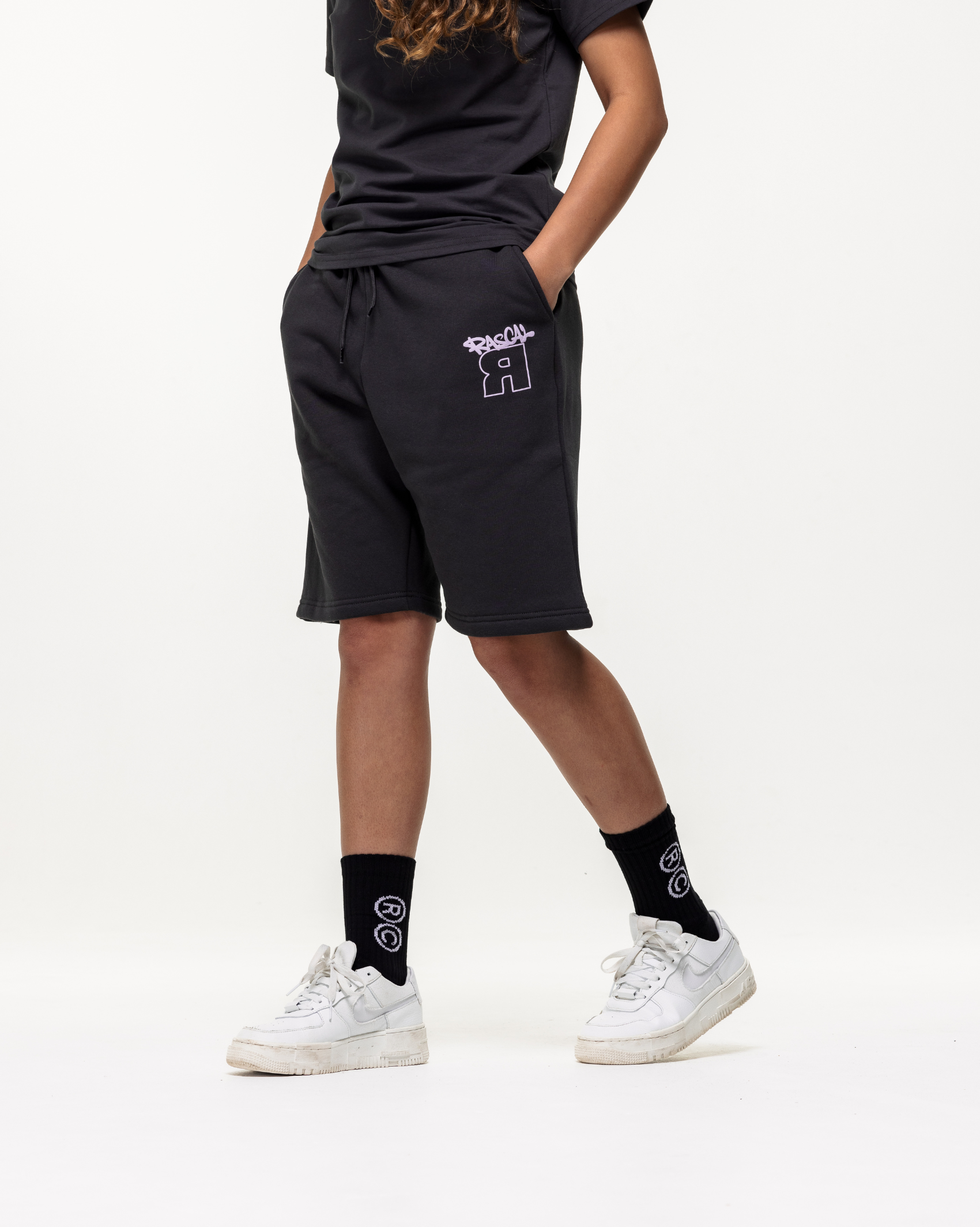 Girl model wearing Rascal Flip Bristol Black Shorts Outfit with matching tee stepping